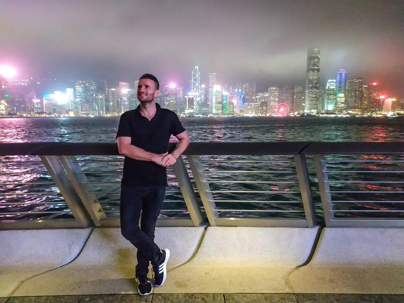 Danny at night in front of the Hong Kong skyline