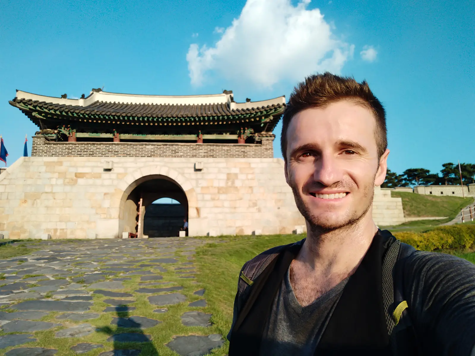 Danny smiling in front of a Korean fortress gate